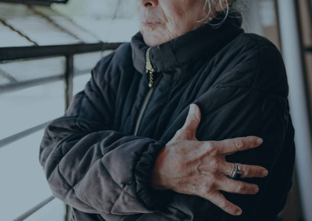 Old woman warming up herself in a cold winter day