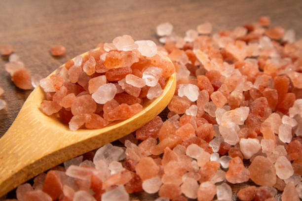 istock Himalayan pink and white crystal salt on spoons and floors which is naturally derived which has more benefits and minerals than any other salt. 2157546258