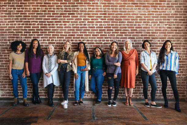 istock Happy woman standing by a brick wall 2157546408