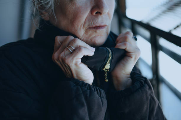 istock Old woman warming up herself in a cold winter day 2157546412