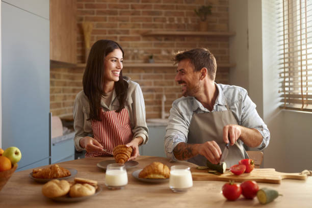 istock Happy couple talking while preparing a meal in the kitchen. 2157546768
