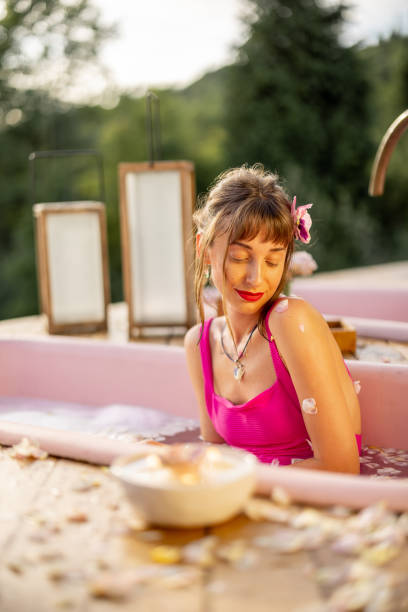 istock Woman lying in pink bathtub during SPA relaxation 2157547460