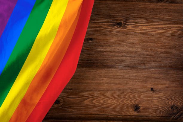 istock Rainbow Pride Flag on Brown Wooden Background 2157549986
