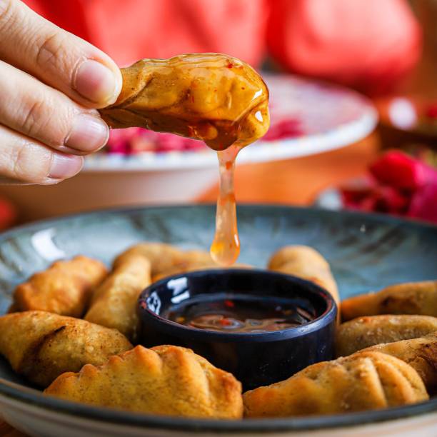 istock Dipping Fried Dumplings in Sweet Chili Sauce 2157551881