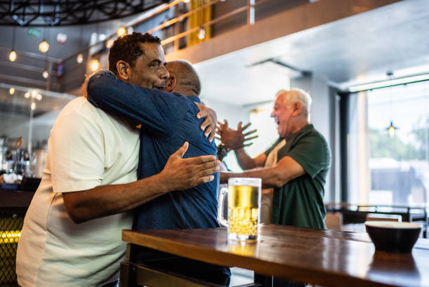 istock Senior friends embracing and celebrating at bar 2157552168