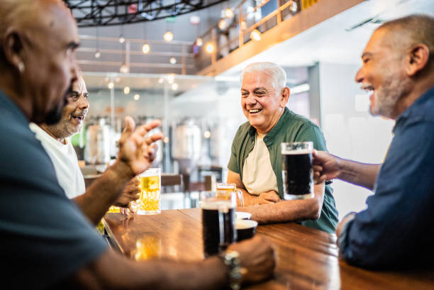 istock Senior friends talking and drinking beer on the bar 2157552176