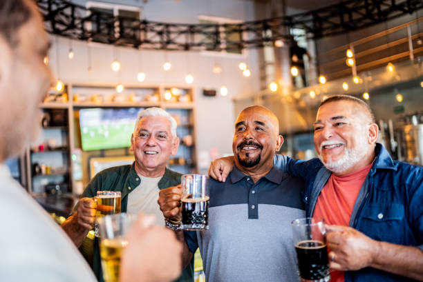 istock Senior friends talking and drinking beer on the bar 2157552220