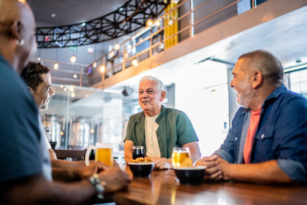 istock Senior friends talking and drinking beer on the bar 2157552343
