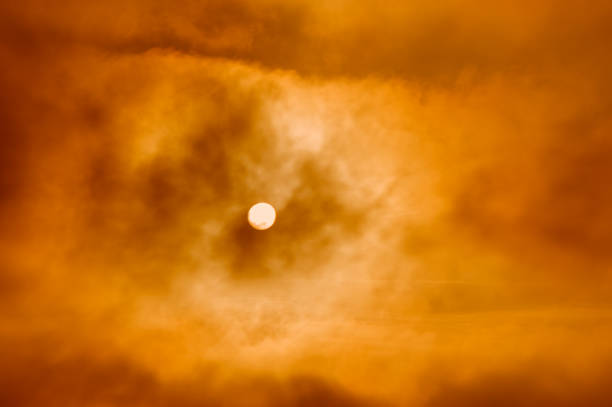 Disk of the setting sun in smoky clouds. Natural background.