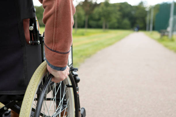 istock Wheelchair user in a public park with copy space 2157557669