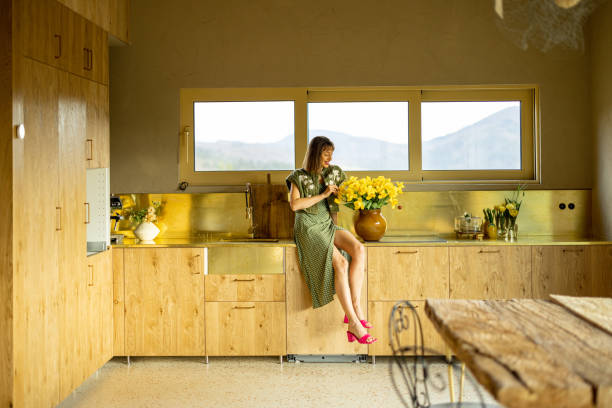 istock Woman with flowers at kitchen 2157558026