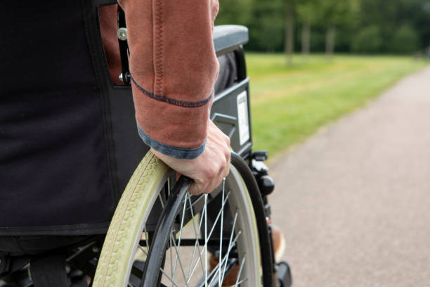 istock Wheelchair user in a public park with copy space 2157558132