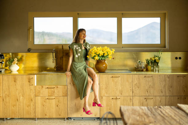 istock Woman with flowers at kitchen 2157558165