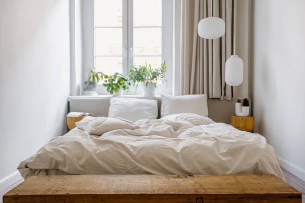 istock Selective focus on empty wooden bench next to comfortable double bed in bedroom 2157561504