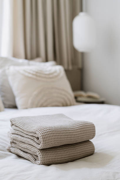 istock Selective focus on fresh cotton beige towels neatly folded on comfortable bed 2157561506