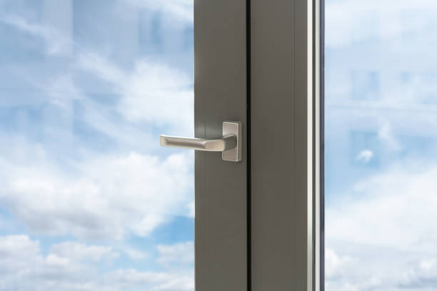 istock Pvc window with silver handle and view on blue sky through transparent glass 2157561715