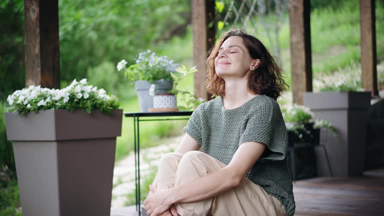 A young Caucasian woman enjoying the fresh air while sitting on the terrace