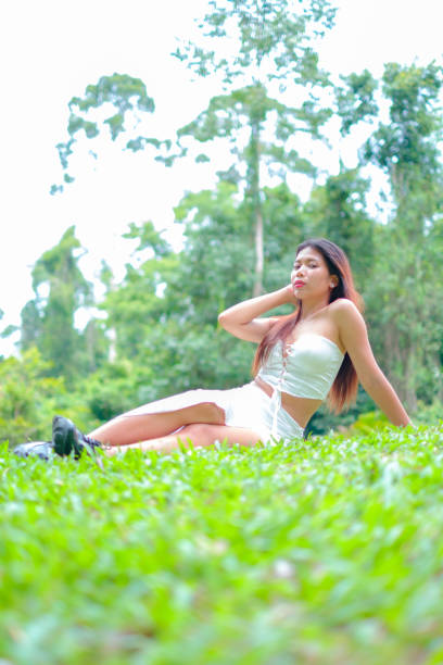 istock Asian girl poses under a tree in a big forest 2157563836