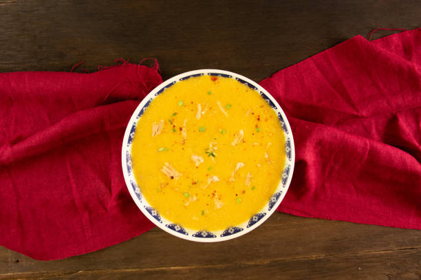 Carrot shredded chicken soup with fresh herbs and pepper