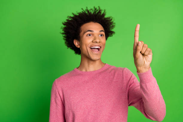 istock Photo of cheerful positive guy dressed pink pullover pressing finger emtpy space isolated green color background 2157573865