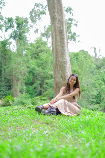 istock Asian woman sitting under a big tree on the mountain 2157577134