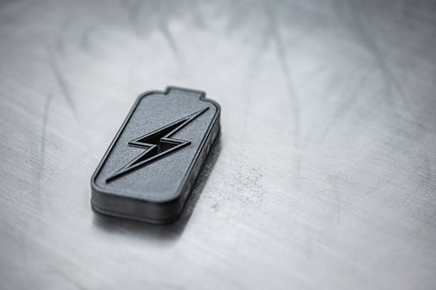 Energy concept. Battery energy technology background. Charged battery icon representing innovative power technologies and sustainability on metallic background. Minimalistic setup with copy space. Elements painted with dark graphite metallic paint