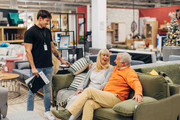 istock A senior couple is thinking about which sofa bed to buy. A friendly salesman helps them 2157581354