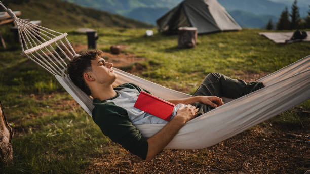 istock Young boy sleep in the hammock after read book on the mountain 2157581822