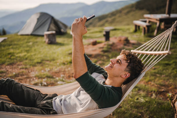 istock Boy lying down in hammock take a self portrait or video call on phone 2157581837