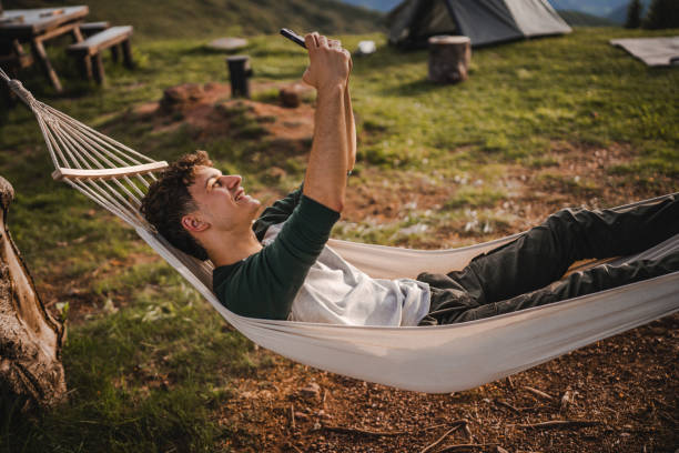 istock Boy lying down in hammock take a self portrait or video call on phone 2157581838