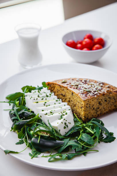 istock Delicious cornbread with arugula, habanero pepper, cherry tomatoes, probiotic yogurt, and young low-fat cheese. A healthy Serbian dish made from cornmeal, known as Proja - Stock Photo 2157582773