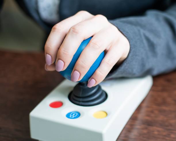 istock Woman with cerebral palsy works on a specialized computer mouse. 2157582788