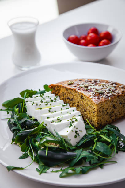 istock Delicious cornbread with arugula, habanero pepper, cherry tomatoes, probiotic yogurt, and young low-fat cheese. A healthy Serbian dish made from cornmeal, known as Proja - Stock Photo 2157582790