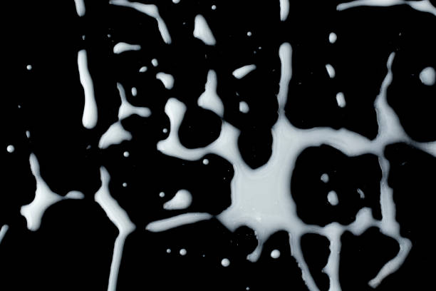 White blot of paint on a black background.