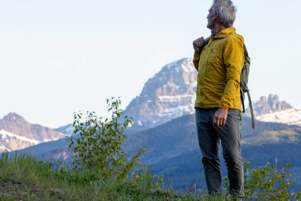 istock Backpacker watches sunrise over snowcapped mountain 2157586471
