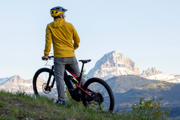 istock Mountain biker looks towards snowcapped mountain 2157586636