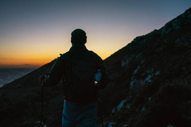 istock Tourist hiking in mountains at sunset 2157587639