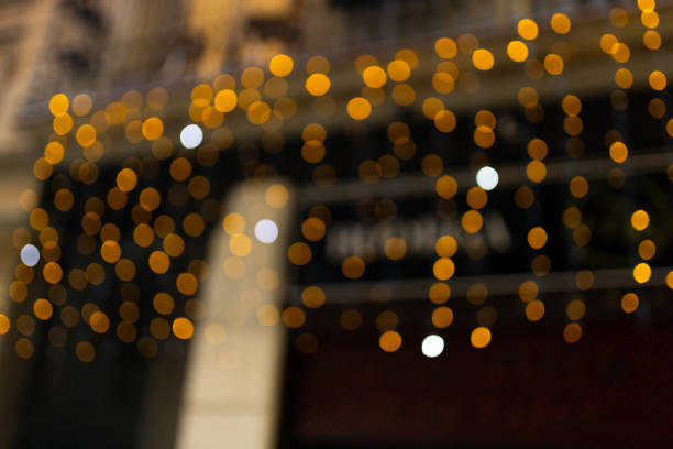 istock Decorative outdoor string lights at night time, Defocused Background, night city life backdrop, party time with Yellow bokeh balls 2157593640
