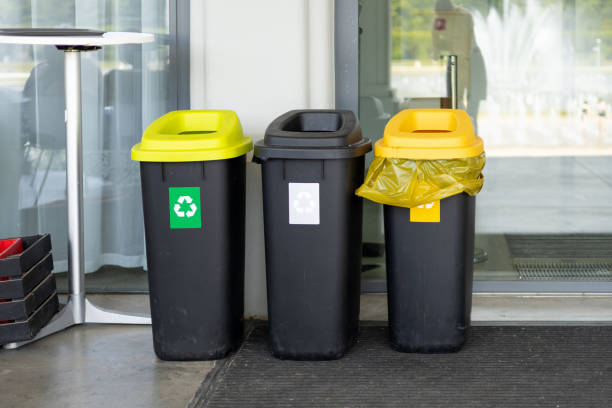 Colorful trash cans for sorting garbage. For plastic, glass, paper and others waste. Waste containers for garbage segregation in Poland, standing next to a wall
