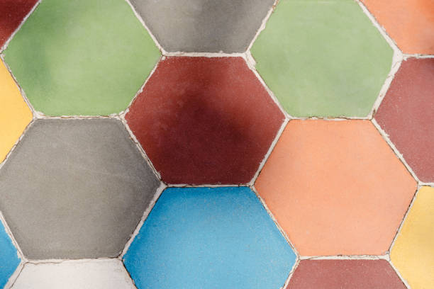 A colorful mosaic tile pattern with a variety of colors. The tiles are arranged in a hexagonal shape, creating a visually appealing and unique design. Scene is vibrant and lively