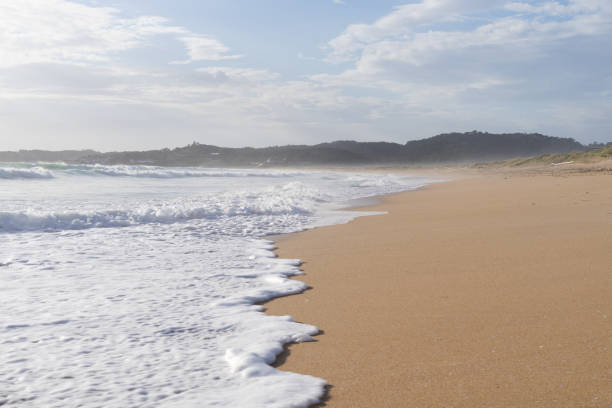 Foamy water on the beach sand. Copy space.