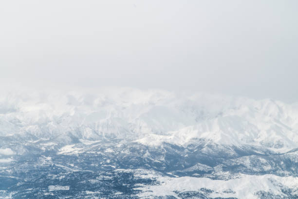 Snowcapped mountains from airplane window. Aerial view.