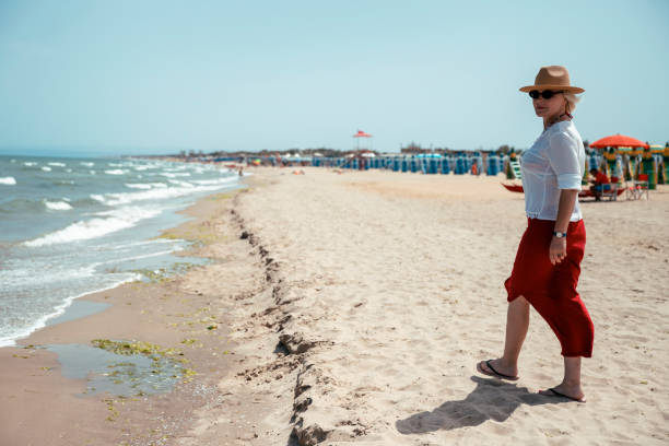 istock Relaxed elderly woman walking on a beach 2157602481
