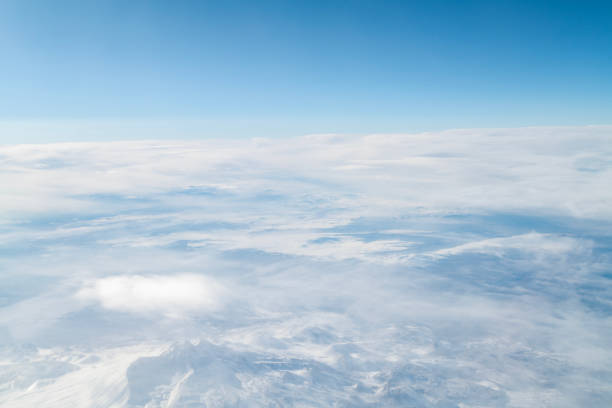 Snowcapped mountains from airplane window. Aerial view.