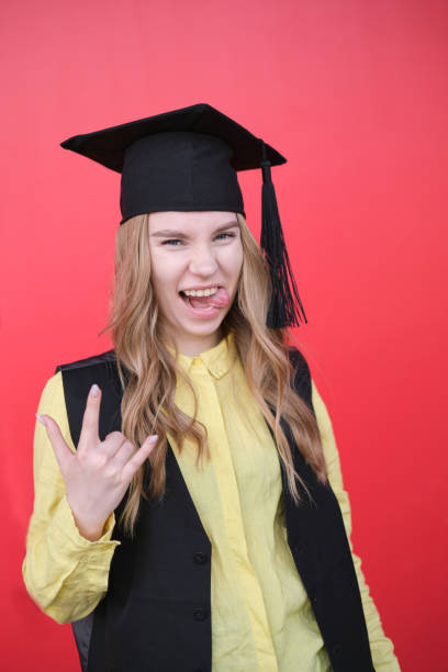 istock Young beautiful blond female in graduation cap with emotional expression 2157605412