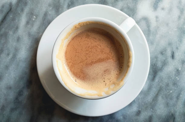 istock half full cup of cappuccino or coffee close up on grey marble stone background 2157607625