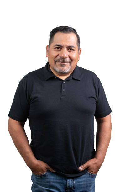 Smiling hispanic mature man posing with his hands in pockets looking at the camera isolated on white background