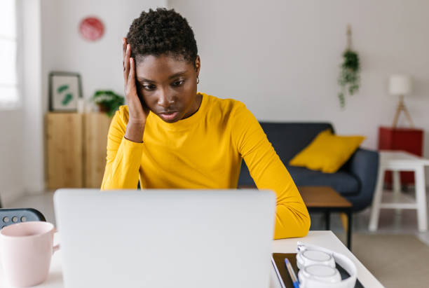 istock Worried young african woman using laptop at home 2157614607