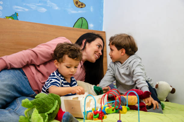 istock latin mom playing with her two sons in bedroom 2157626391