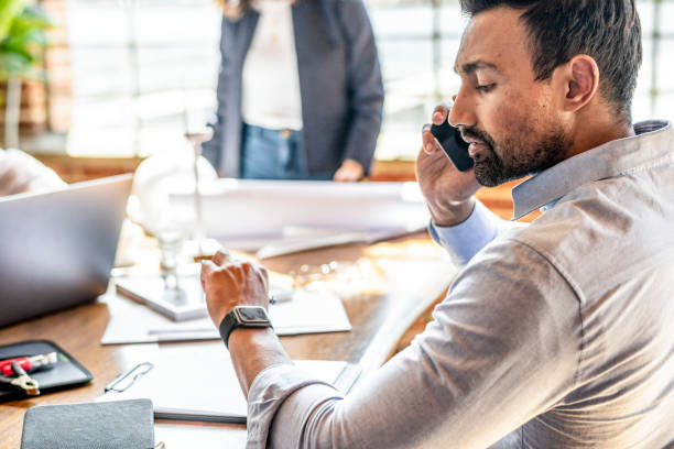 istock Businessman checking on his smartwatch while talking on the phone 2157631808
